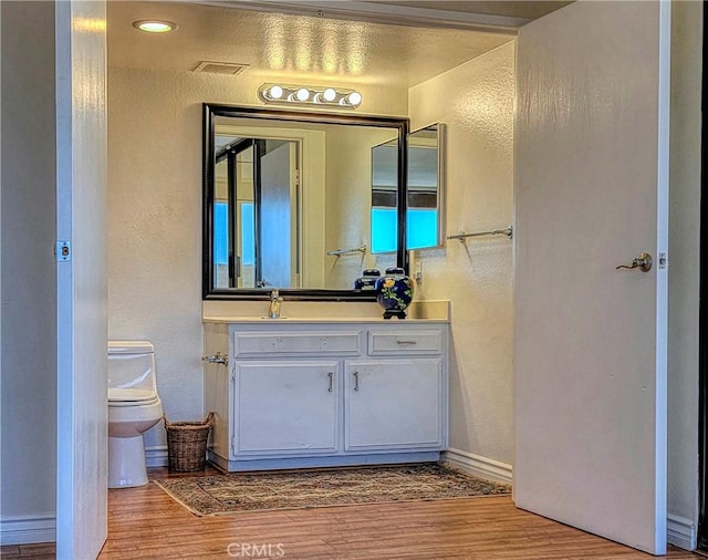24055 Paseo Del Lago W Unit 1455, Laguna Woods, CA 92637 - half bathroom with a textured wall, wood finished floors, toilet, and vanity