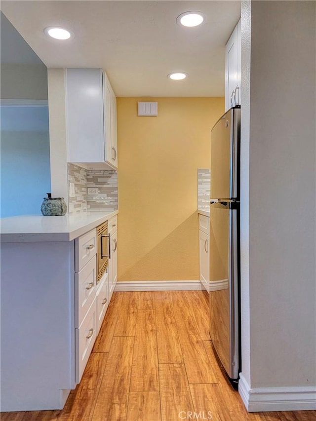 24055 Paseo Del Lago W Unit 1455, Laguna Woods, CA 92637 - kitchen featuring white cabinetry, tasteful backsplash, appliances with stainless steel finishes, and light wood-type flooring