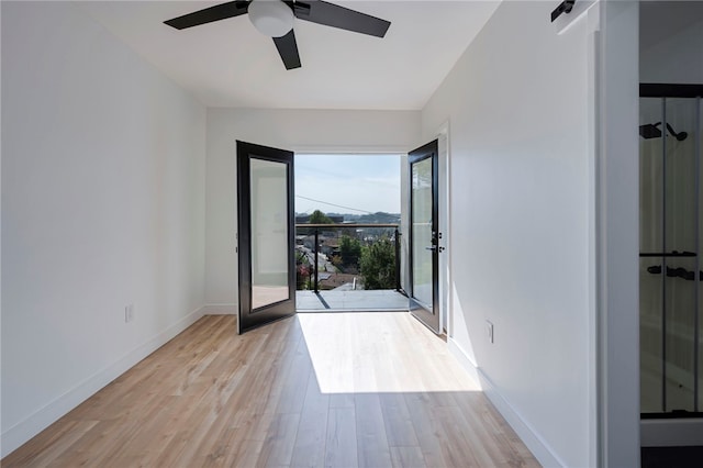 empty room with light wood finished floors, baseboards, and ceiling fan