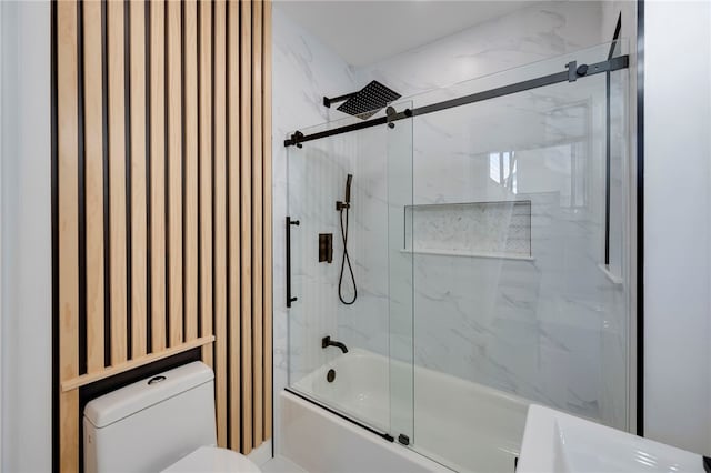 bathroom featuring shower / bath combination with glass door and toilet