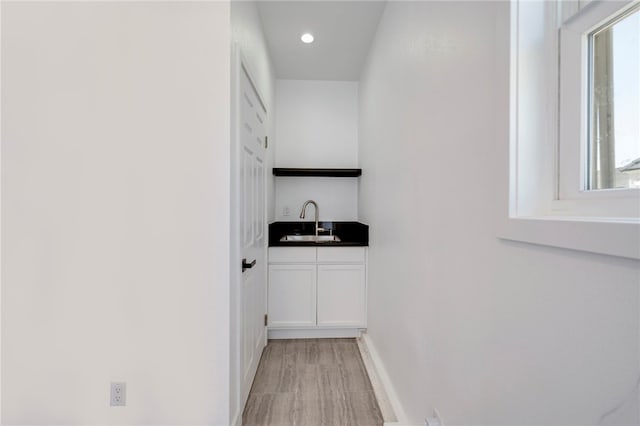 laundry area featuring plenty of natural light, indoor wet bar, a sink, and recessed lighting