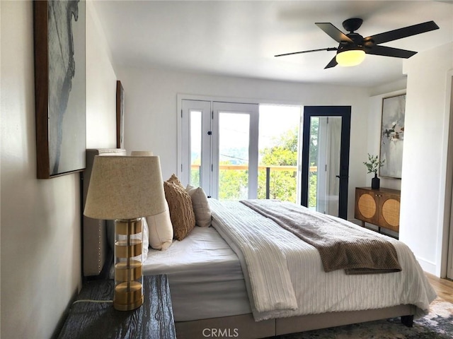 bedroom featuring a ceiling fan, wood finished floors, and access to exterior