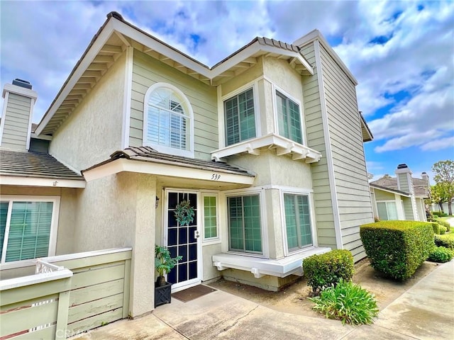 rear view of house featuring a patio and stucco siding