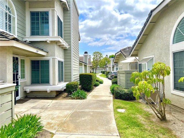 view of side of home with a patio area, stucco siding, and a residential view