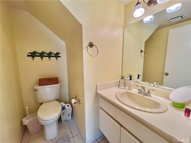 half bath featuring vanity, tile patterned flooring, toilet, and visible vents