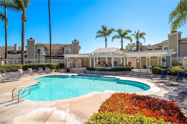 community pool with a patio, fence, and a pergola