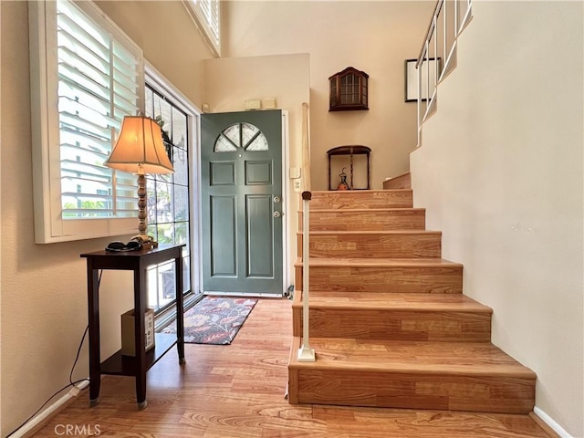 entrance foyer featuring baseboards, stairs, and wood finished floors