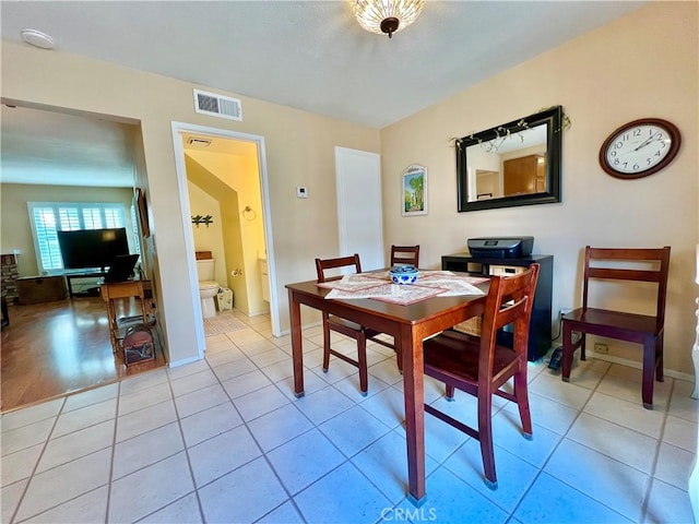 dining area featuring light tile patterned floors, baseboards, and visible vents