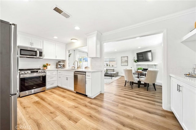 22287 Modina, Laguna Hills, CA 92653 - kitchen with appliances with stainless steel finishes, ornamental molding, light countertops, white cabinets, and a sink