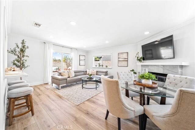 22287 Modina, Laguna Hills, CA 92653 - dining area featuring a fireplace, light wood-style flooring, ornamental molding, recessed lighting, and baseboards