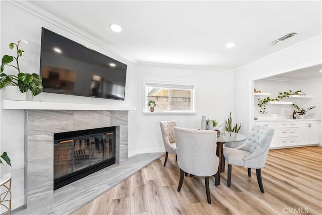 22287 Modina, Laguna Hills, CA 92653 - dining area featuring light wood-style flooring, a fireplace, ornamental molding, recessed lighting, and baseboards