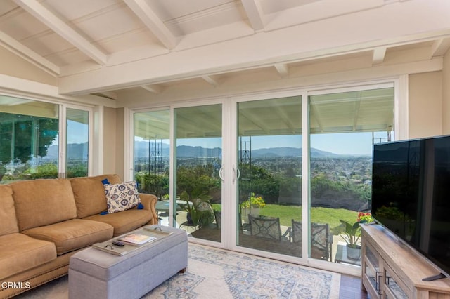 sunroom featuring wood finished floors and vaulted ceiling with beams