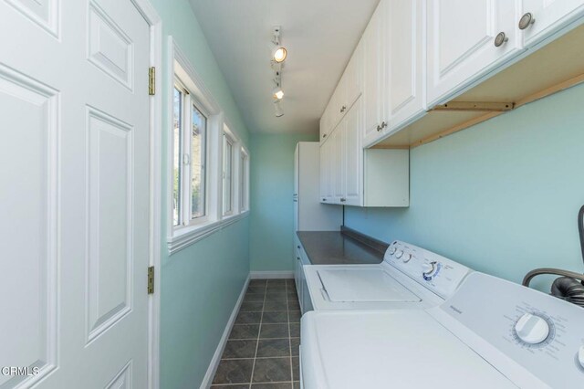 laundry area with baseboards, dark tile patterned floors, rail lighting, cabinet space, and independent washer and dryer
