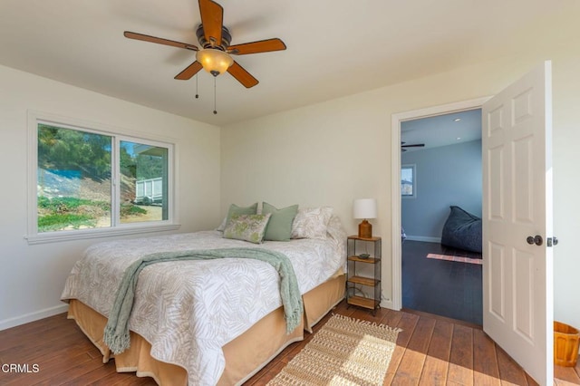 bedroom with a ceiling fan, baseboards, and wood-type flooring