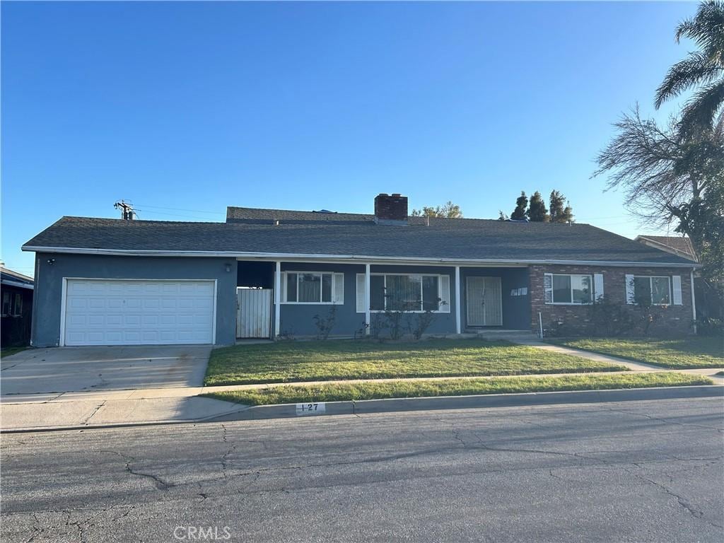 127 W Valencia St, Rialto, CA 92376 - single story home with a garage, a front yard, central AC, and concrete driveway