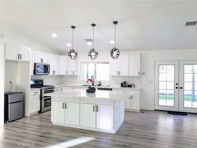 67685 Verona Rd, Cathedral City, CA 92234 - kitchen featuring a sink, white cabinetry, vaulted ceiling, stainless steel appliances, and a kitchen island