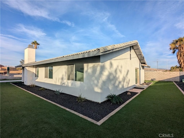 67685 Verona Rd, Cathedral City, CA 92234 - view of home's exterior featuring a chimney, fence, a lawn, and stucco siding