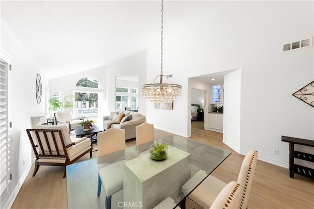 4 Malaquita, Coto De Caza, CA 92679 - dining area with high vaulted ceiling, a chandelier, baseboards, visible vents, and light wood-style floors