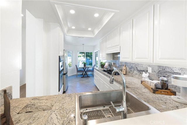 4 Malaquita, Coto De Caza, CA 92679 - kitchen with white cabinets, ornamental molding, a sink, a tray ceiling, and backsplash