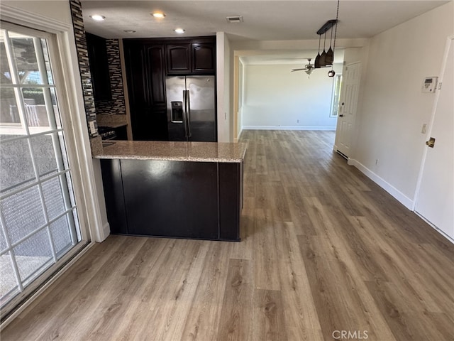 7524 Matterhorn Ave, Rancho Cucamonga, CA 91730 - kitchen featuring stainless steel fridge with ice dispenser, wood finished floors, light stone counters, a peninsula, and recessed lighting