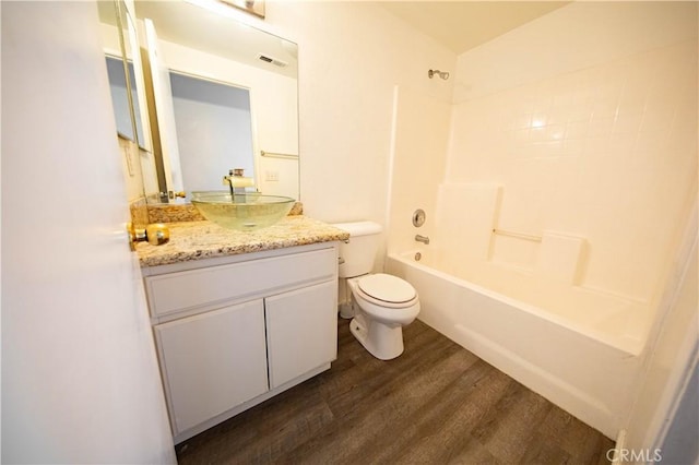 full bath featuring visible vents, toilet, wood finished floors, shower / bath combination, and vanity
