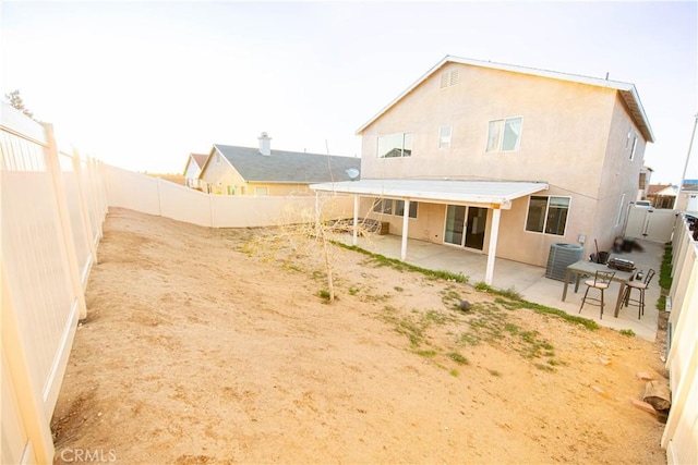 back of house featuring a patio, central air condition unit, a fenced backyard, and stucco siding