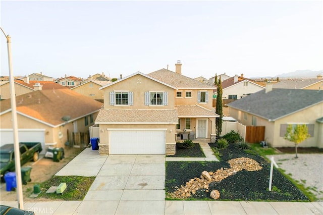traditional-style home with fence, a residential view, driveway, and stucco siding