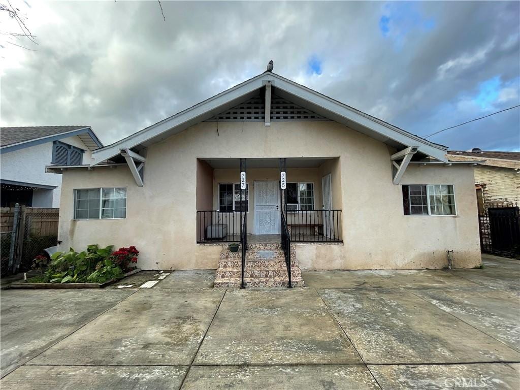 725727 W 50th St, Los Angeles, CA 90037 - bungalow-style house featuring stucco siding, a porch, and fence
