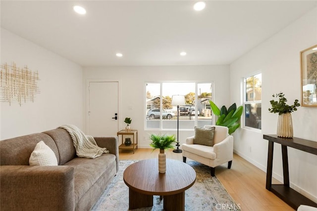 living area featuring recessed lighting, baseboards, and light wood finished floors