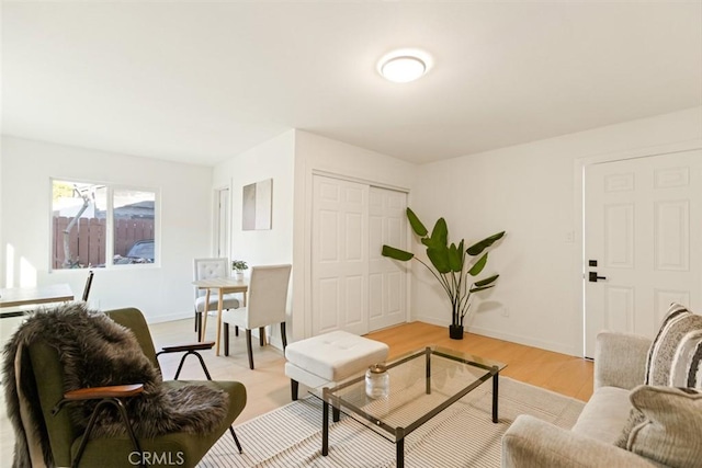 living area featuring light wood-style flooring and baseboards