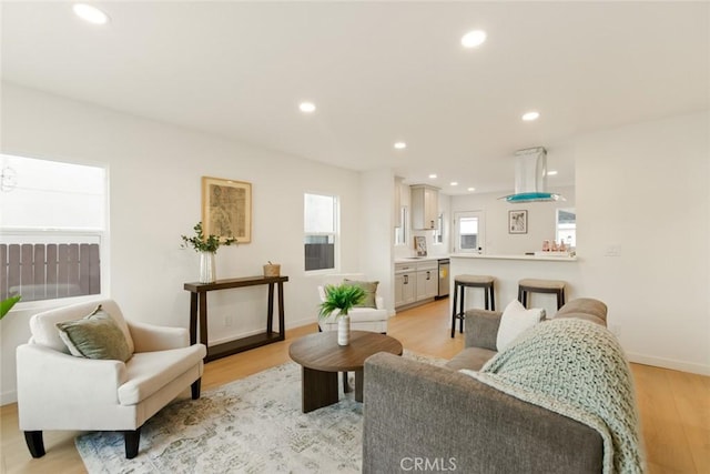 living room with recessed lighting, light wood-style floors, and baseboards