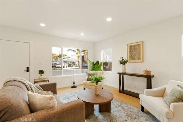 living room with recessed lighting, baseboards, and light wood-style floors