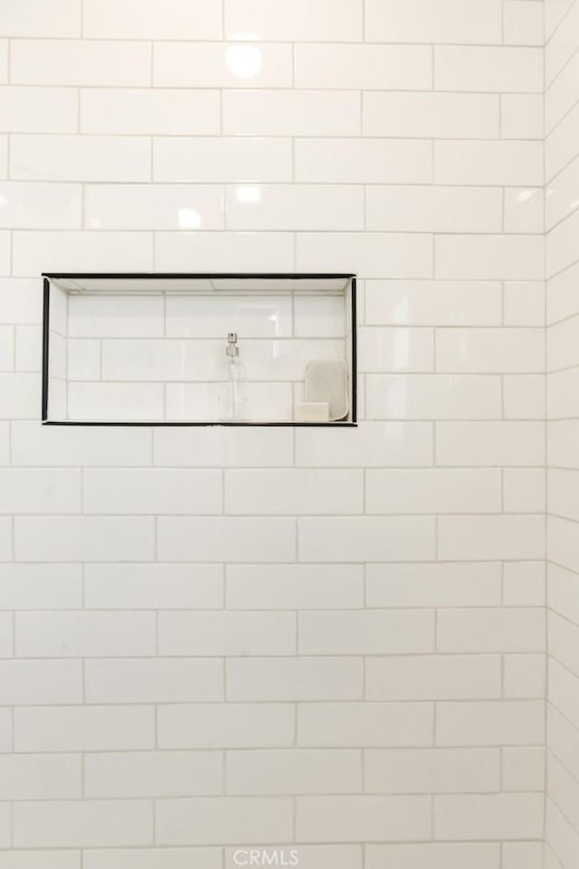 interior details featuring tiled shower