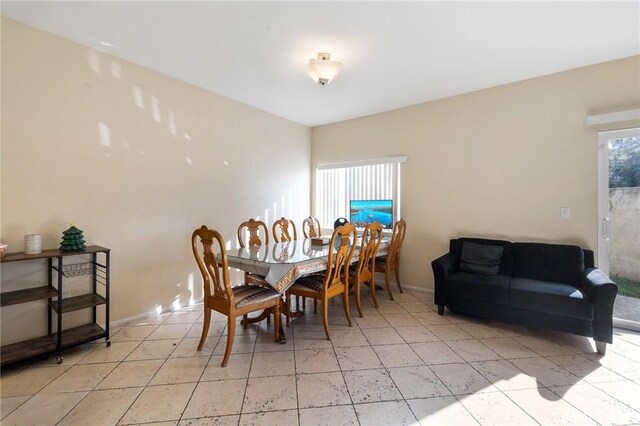 dining space with baseboards and light tile patterned floors