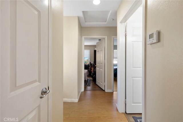 hallway with light wood-style flooring and baseboards