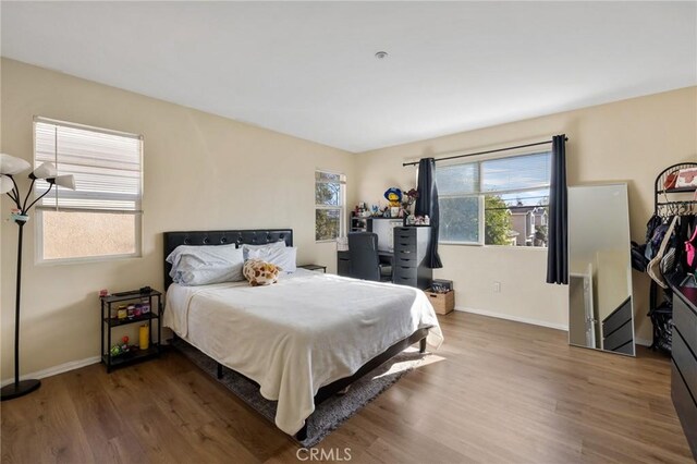 bedroom featuring baseboards and wood finished floors