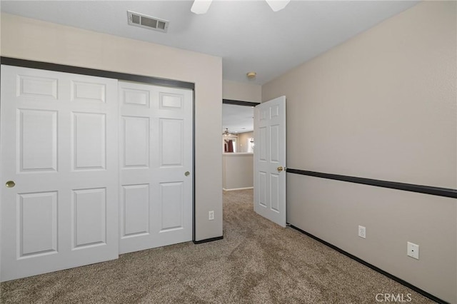 unfurnished bedroom with visible vents, baseboards, a closet, a ceiling fan, and carpet floors