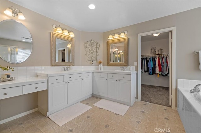 bathroom featuring tile patterned floors, recessed lighting, vanity, and a garden tub