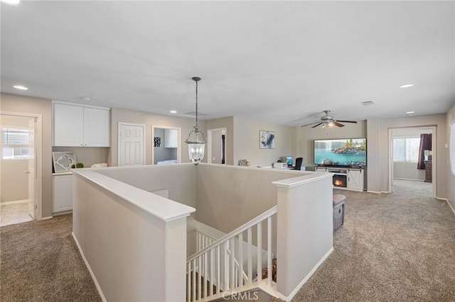hallway with recessed lighting, an upstairs landing, light carpet, and baseboards