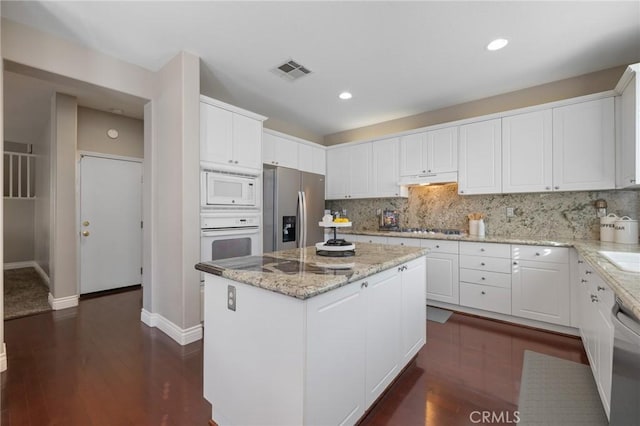 kitchen with white cabinetry, visible vents, a center island, under cabinet range hood, and stainless steel appliances