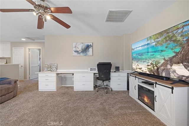 office area featuring visible vents, ceiling fan, and light carpet