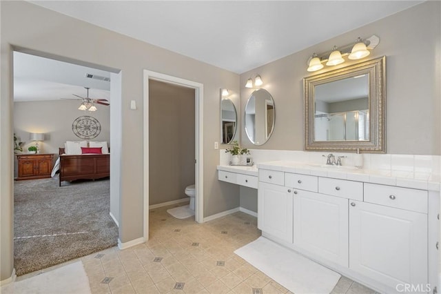 ensuite bathroom featuring ensuite bathroom, ceiling fan, visible vents, toilet, and baseboards