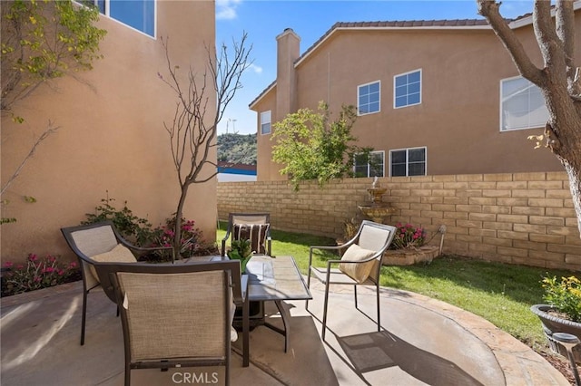 view of patio with outdoor dining space and fence