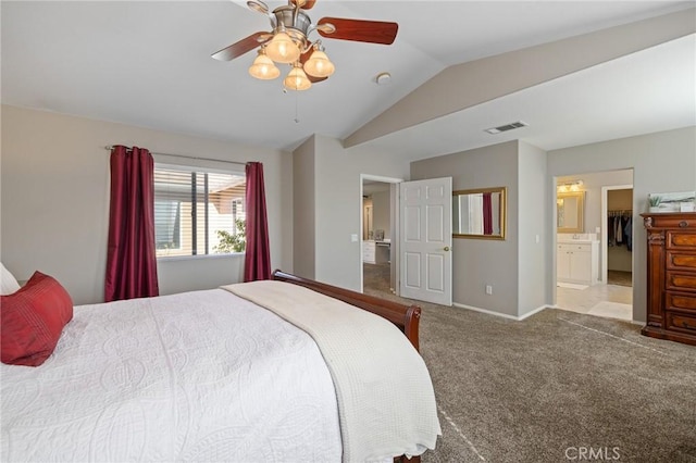 bedroom featuring ensuite bath, vaulted ceiling, visible vents, carpet floors, and baseboards
