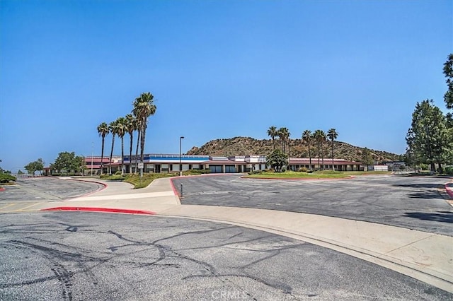 view of road featuring sidewalks, a mountain view, and curbs