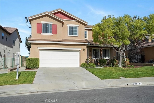 view of front of property with concrete driveway, stucco siding, an attached garage, a front yard, and fence