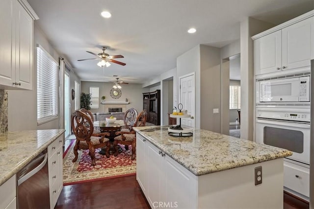 kitchen featuring a ceiling fan, dark wood-type flooring, a healthy amount of sunlight, and white appliances
