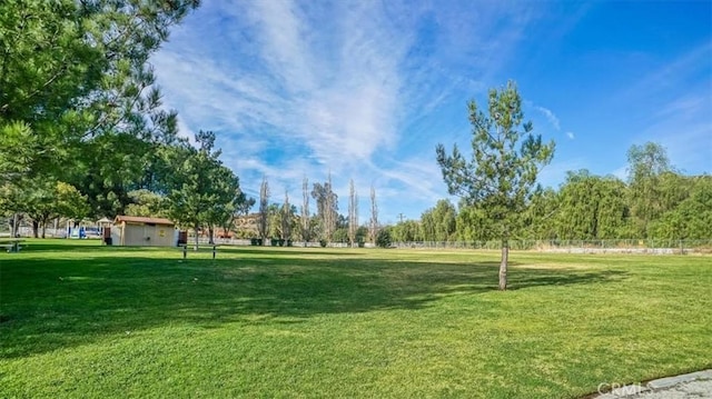 view of property's community with a yard and an outdoor structure