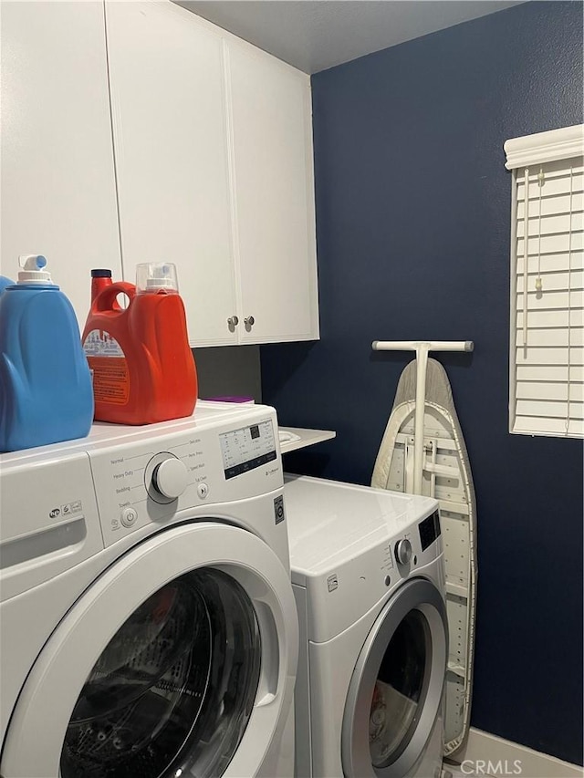 laundry room with independent washer and dryer and cabinet space