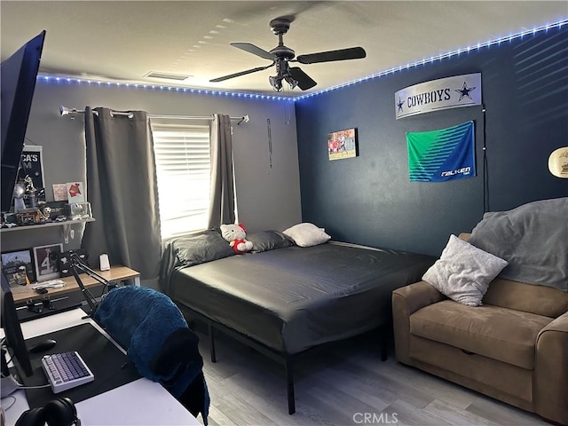 bedroom featuring visible vents, wood finished floors, and ceiling fan